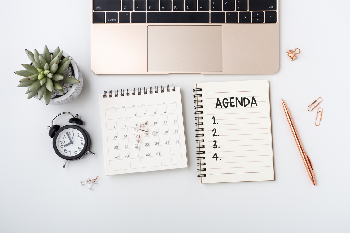 Business meeting agenda concept on white desk, flat lay